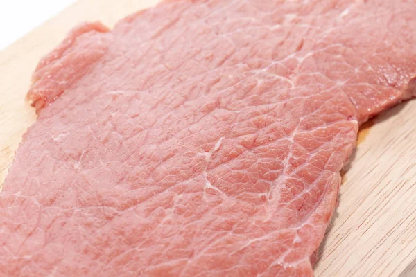 Close-up do lado superior da carne crua na placa de madeira — Fotografia de Stock