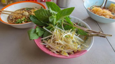 Sebze, fesleğen ve fasulye filizlerini kaseye koy.