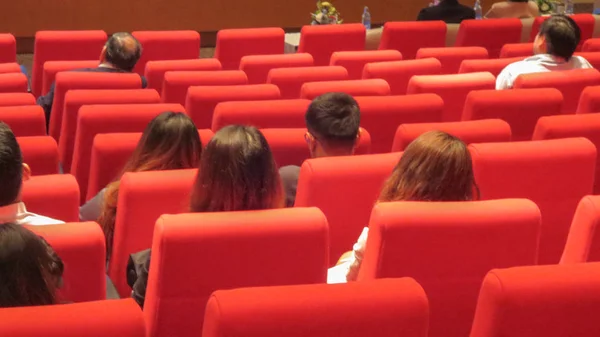 Ludzie i rząd czerwonego fotela w sali seminaryjnej — Zdjęcie stockowe