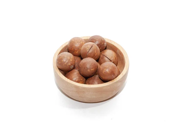 Close-up van biologische macadamia noot op houten schaal op witte achtergrond — Stockfoto