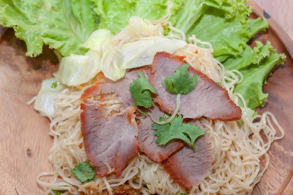 Egg noodle soup with red roasted pork on wooden plate — ストック写真