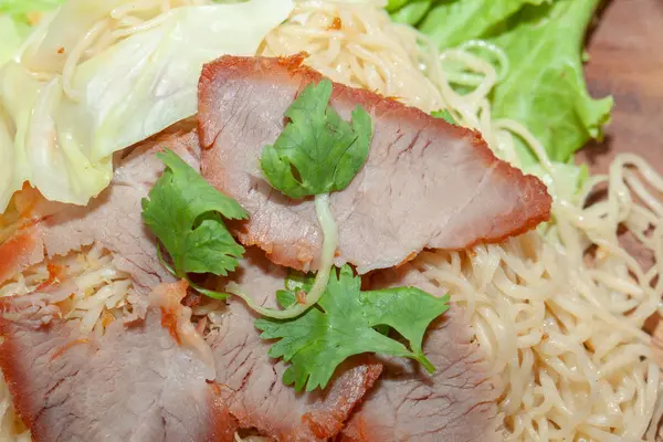 Egg noodle soup with red roasted pork on wooden plate — ストック写真