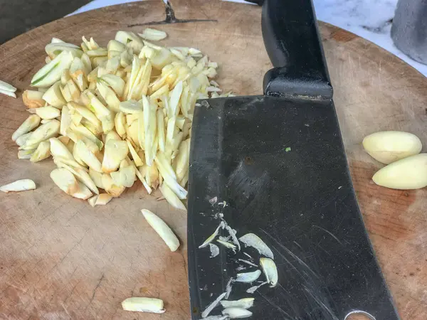 Primo piano di coltello e aglio tritato su una tavola di legno . — Foto Stock