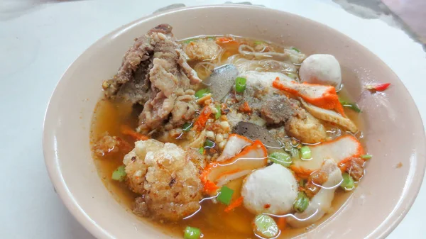 Ciotola di piccante Tom yum zuppa di tagliatelle con carne di maiale in stile tailandese — Foto Stock