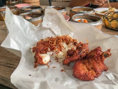 Kızarmış tavuk ve yapışkan pirinci kağıda sarın.