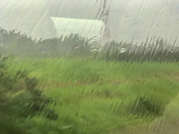 Caduta di pioggia su finestre di vetro con treno in rapido movimento — Foto Stock