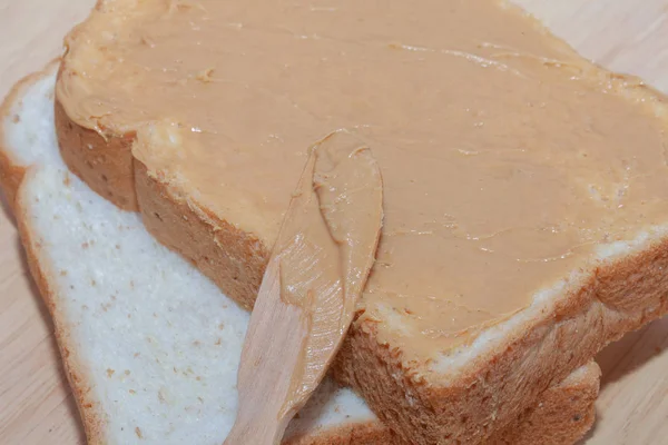 Pan sándwich de mantequilla de maní en plato de madera — Foto de Stock