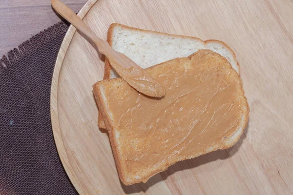 Pan sándwich de mantequilla de maní en plato de madera — Foto de Stock