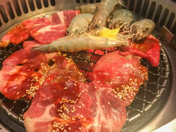 Preparing shrimp and beef with sesame sauce on beef barbecue grill — 스톡 사진