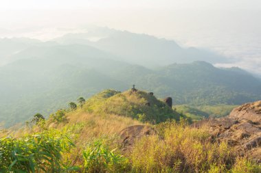 Adam Kanchanaburi, Tayland 'daki dağın tepesinde duruyor.