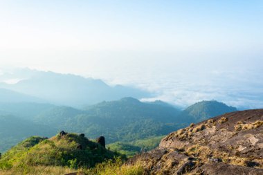 Adam Kanchanaburi, Tayland 'daki dağın tepesinde duruyor.