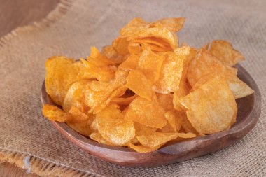 Tahta kasede çıtır patates cipsi yakın.