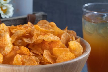 Tahta kasede çıtır patates cipsi yakın.