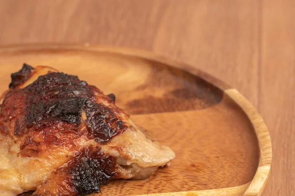 Close up of grilled chiken on wooden plate — 스톡 사진