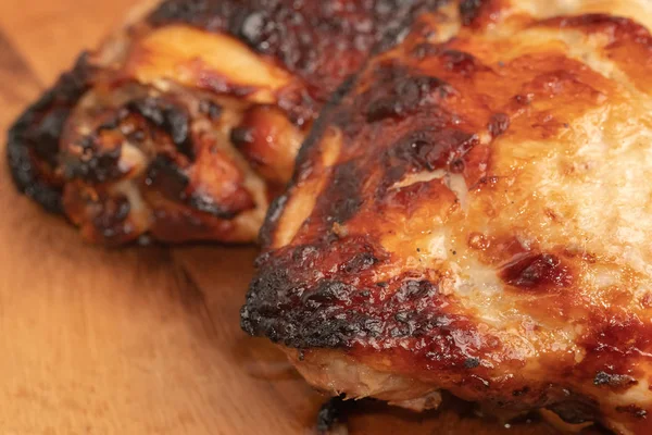 Крупным планом жареного цыпленка на деревянной тарелке — стоковое фото