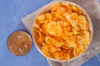 Tahta kasenin üzerinde patates cipsi yatıyordu.