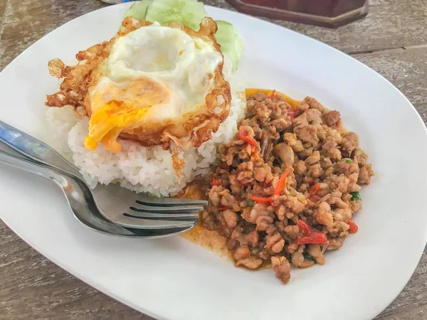 Porc frit thaïlandais et basilic servi avec du riz et des œufs frits — Photo