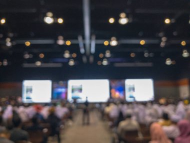 Seminer salonundaki bir sürü insan bulanık.