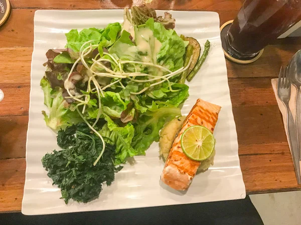 Salmón y ensalada en plato blanco en Tailandia — Foto de Stock