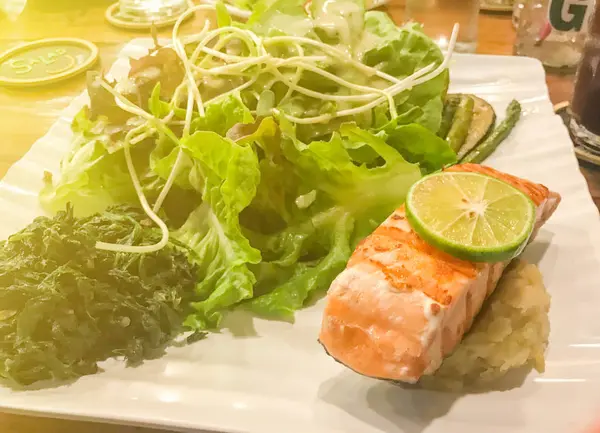 Лосось и салат на белой тарелке в Таиланде — стоковое фото