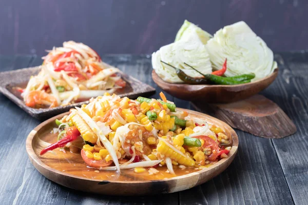 Салат из кукурузы и папайи на деревянной тарелке — стоковое фото