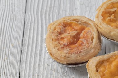 close up of egg tarts on wooden plate