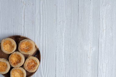 close up of egg tarts on wooden plate