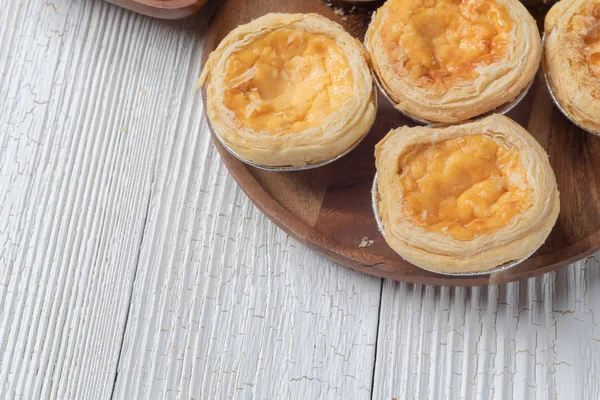 Primer plano de tartas de huevo en plato de madera — Foto de Stock