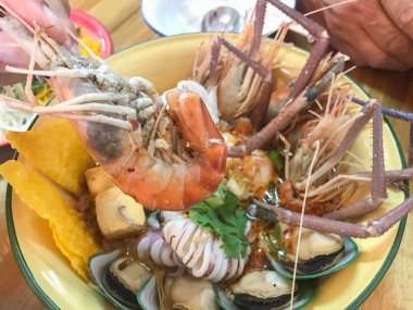 Büyük kâse üzerinde çeşitli deniz ürünleri karidesleri ve baharatlı şehriye.