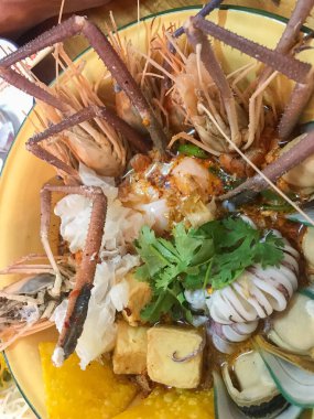 Büyük kâse üzerinde çeşitli deniz ürünleri karidesleri ve baharatlı şehriye.