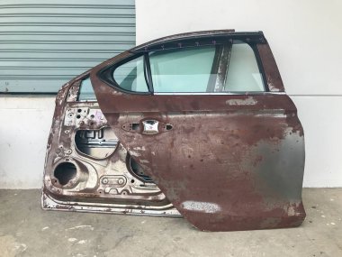 Eski arabanın eski paslı ve hasarlı boyası soyuluyor.