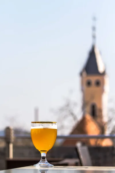 A glass of beer against the background of old buildings — Stock Photo, Image