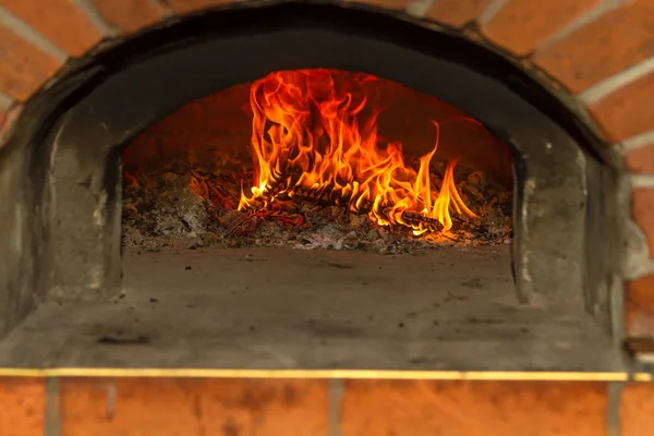Le feu brûle dans un four à pizza au bois — Photo