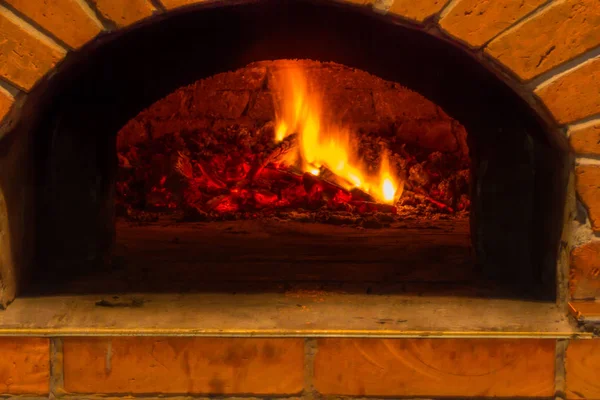 Огонь горит в дровяной печи для пиццы — стоковое фото
