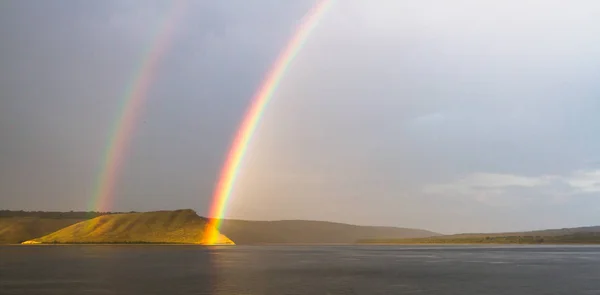 Double rainbow above the reservoir, Bakota Stock Photo