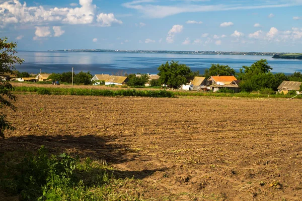 The Dnieper River, houses of Ukrainian peasants, fields, plowed