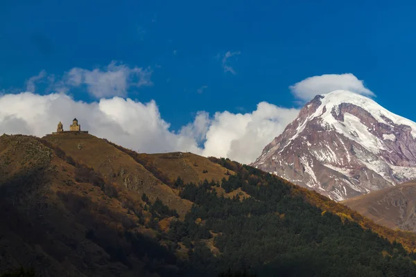 Antica chiesa della Trinità e una montagna innevata di Kazbegi — Foto Stock