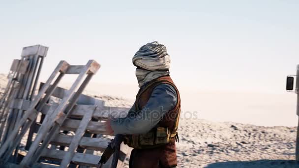 Hombre terrorista usando una máscara y sosteniendo un arma. Paisaje del desierto oriental. cuartel general militar, base terrorista . — Vídeo de stock