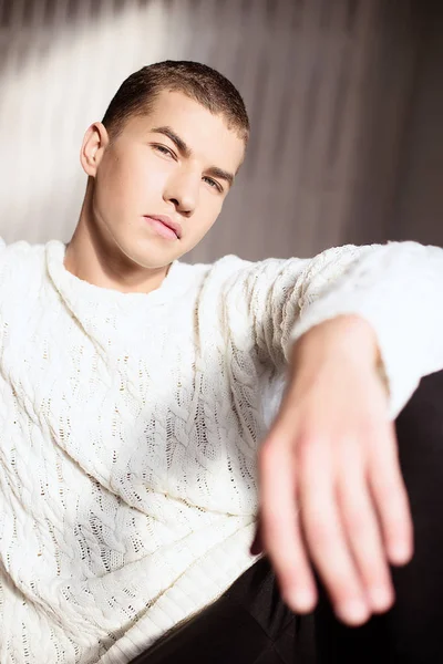 Портрет человека в белом свитере в студии с дневным светом — стоковое фото