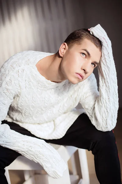 Προσωπογραφία άνδρα στο λευκό πουλόβερ στο studio με φως ημέρας — Φωτογραφία Αρχείου