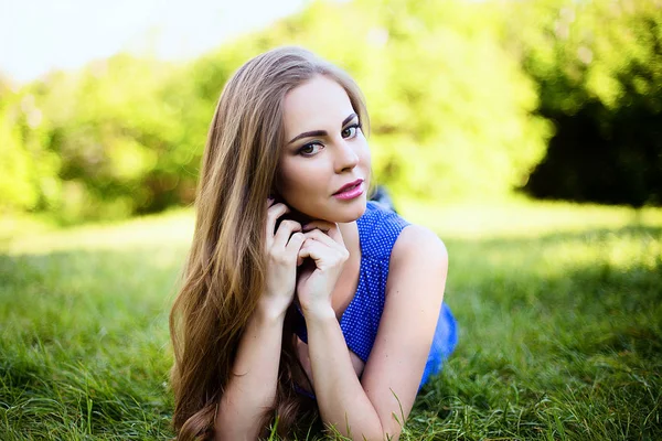 Bahçede çimlerin üzerine mavi elbiseli kız portresi