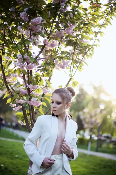 Портрет девушки в белом костюме в парке — стоковое фото