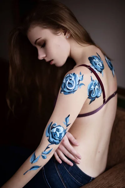 Flicka i underkläder med blå rosor kropp konst måleri — Stockfoto