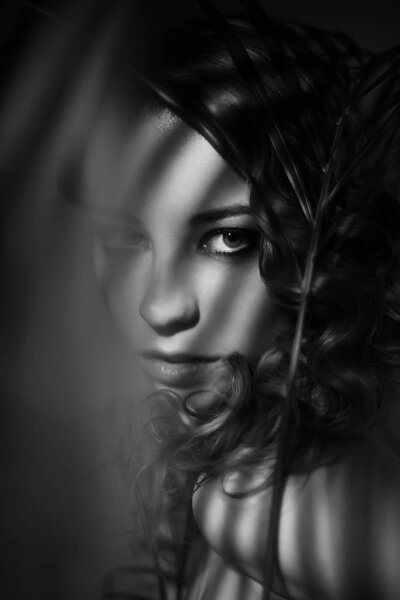 Dramatic black and white portrait of girl with shadows on her face