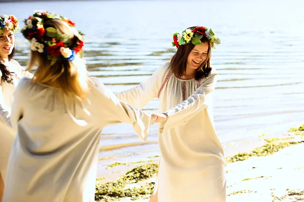 Girls in ethnic clothes with wreath of flowers celebrating