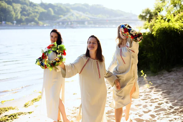 Girls in ethnic clothes with wreath of flowers celebrating