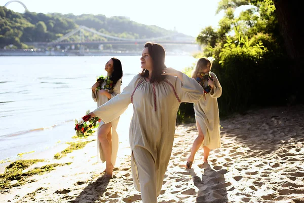 Girls in ethnic clothes with wreath of flowers celebrating