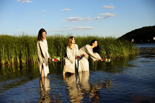 Girls in ethnic clothes with wreath of flowers celebrating