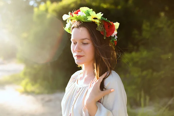 Girl in ethnic clothes with wreath of flowers celebrating