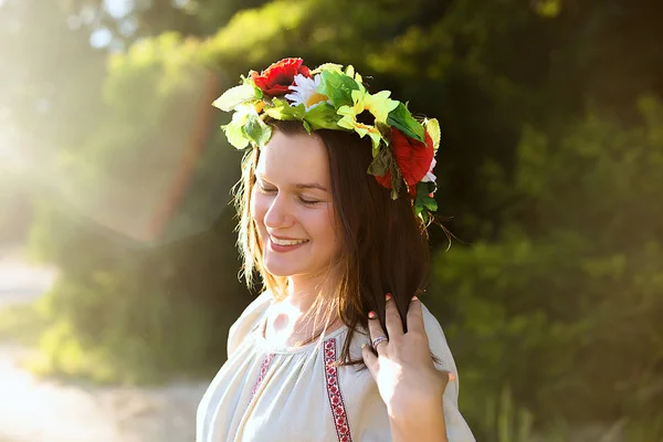 Girl in ethnic clothes with wreath of flowers celebrating